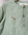 A light green button-down shirt with a small embroidered rabbit design on the front.