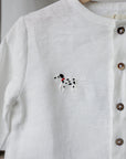 A white button-up shirt with a small embroidered dog design on the front.