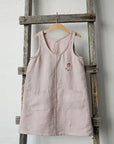 a pink top hanging on a wooden ladder