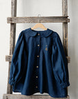 a blue shirt hanging on a wooden ladder