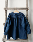 a blue shirt hanging on a wooden ladder