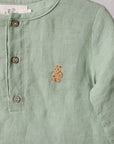 A light green button-down shirt with a small embroidered teddy bear design on the front.