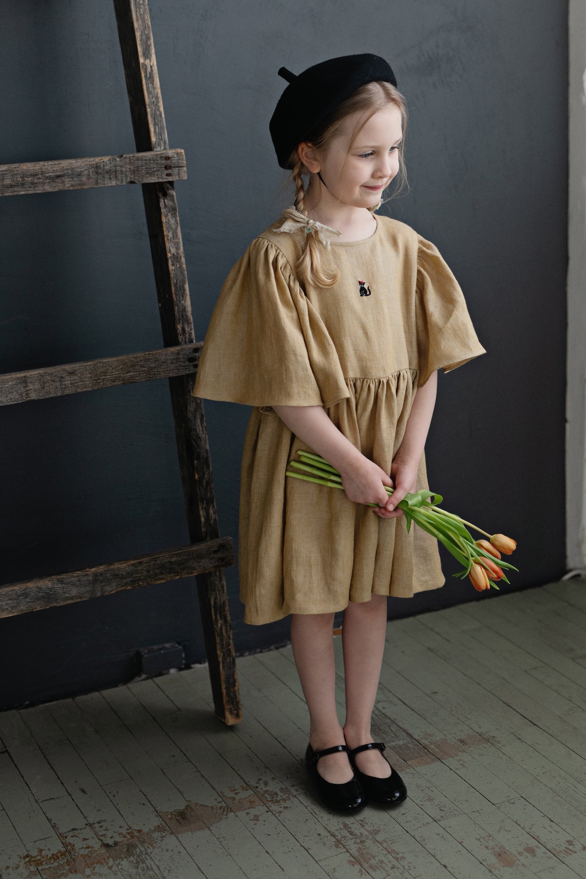 a little girl holding a bunch of flowers