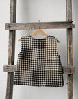 a black and white checkered dress hanging on a wooden ladder