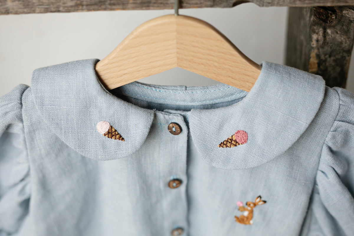 a blue shirt with a wooden hanger on it