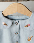 a blue shirt with a wooden hanger on it