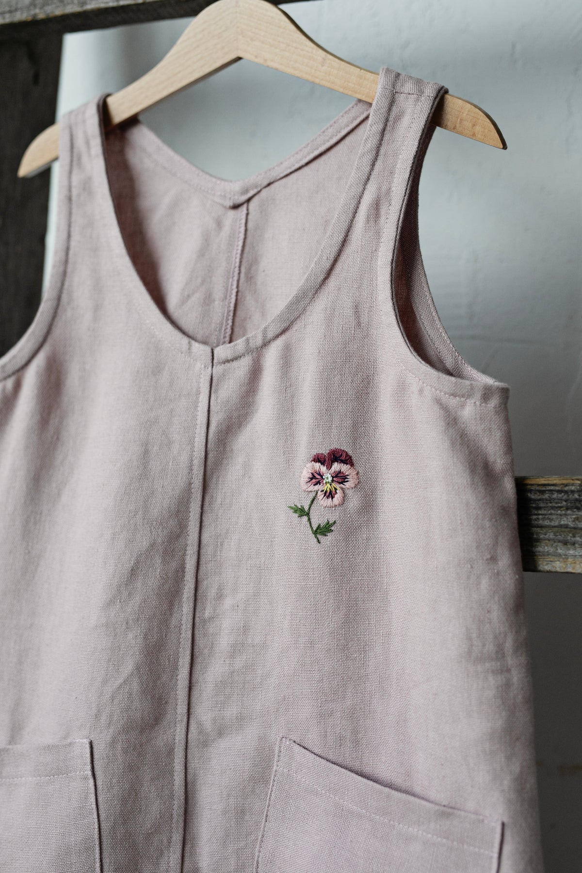 a pink top with a flower embroidered on it