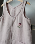 a pink top with a flower embroidered on it