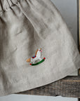 a grey skirt with a small embroidered image of a horse on it.