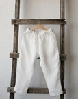 a white pair of pants hanging on a wooden ladder