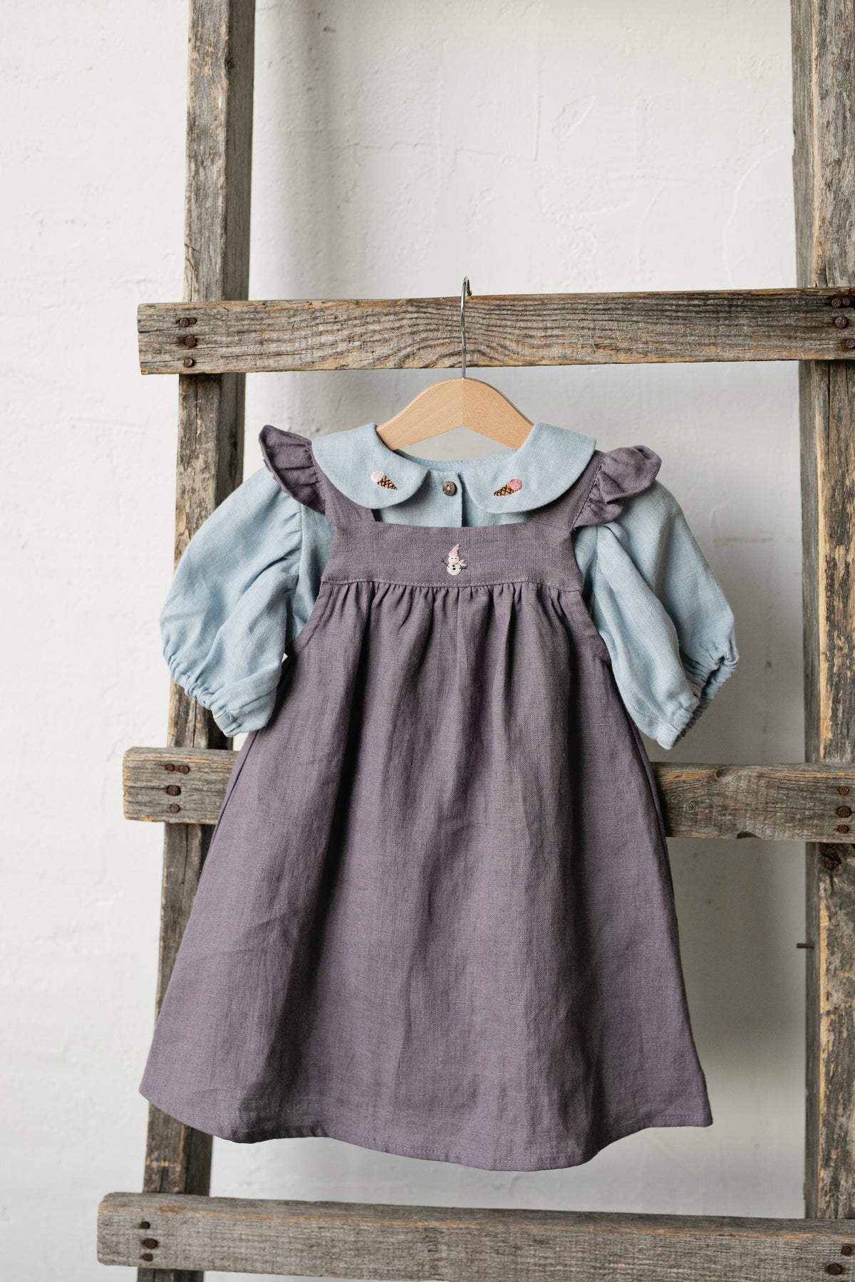 a wooden ladder with a dress hanging on it