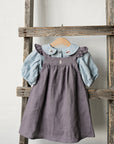 a wooden ladder with a dress hanging on it