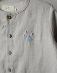 A gray button-up shirt with a small embroidered design on the front.