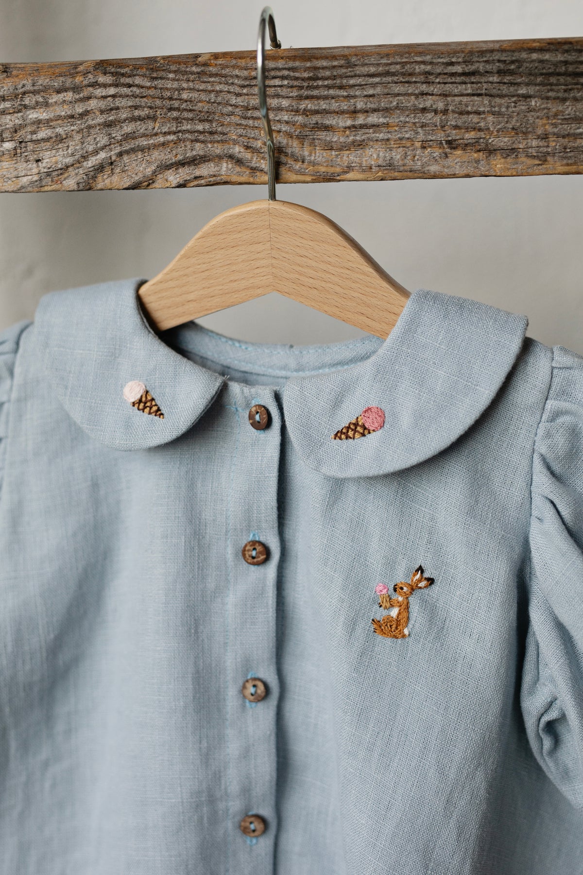 a blue shirt with a deer embroidered on it