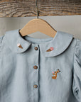 a blue shirt with a deer embroidered on it