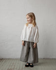 a little girl standing on a wooden floor