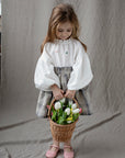 a little girl holding a basket of flowers