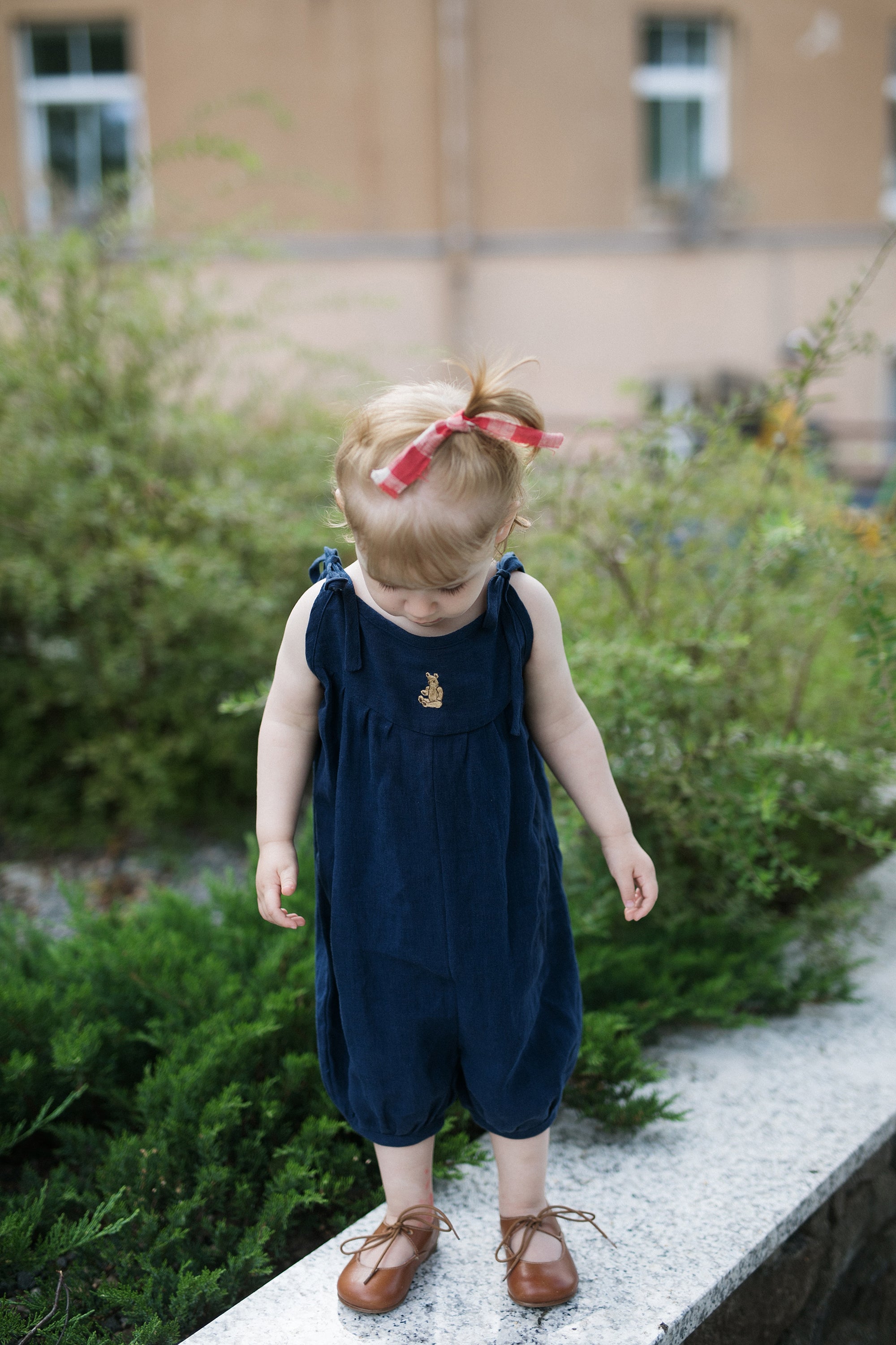 a little girl that is standing on a ledge