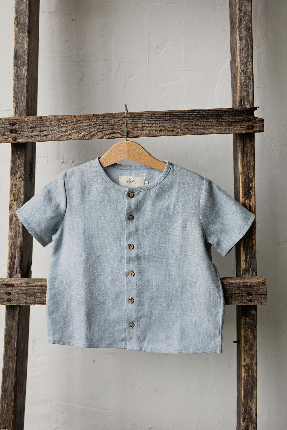 a blue shirt hanging on a wooden ladder