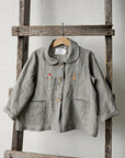 a gray jacket hanging on a wooden ladder