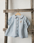 a blue shirt hanging on a wooden ladder