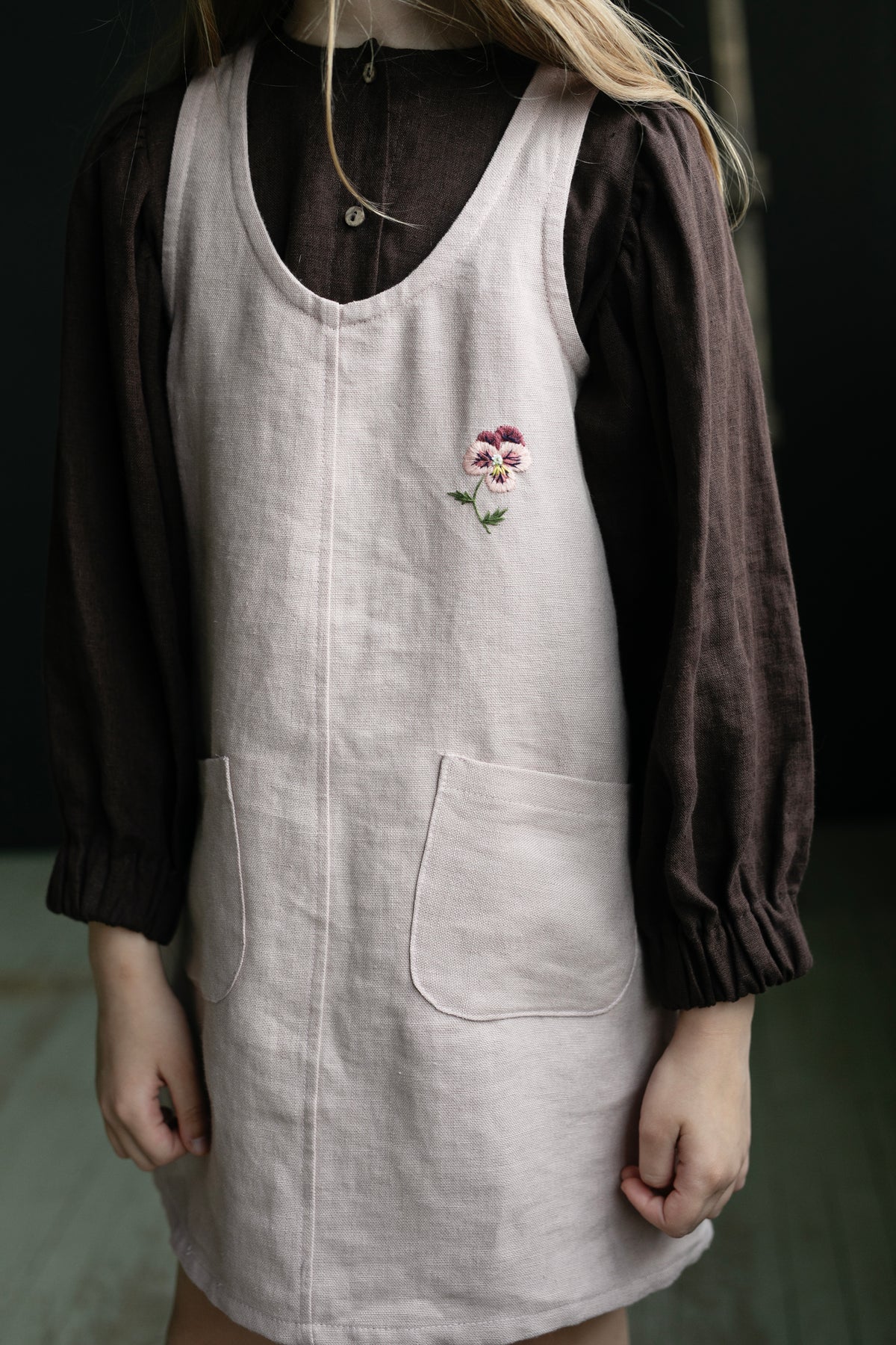 a little girl wearing a dress with a flower on it